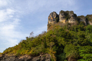 Fototapeta na wymiar mountains and rocks covered with trees against a blue sky with clouds. Thailand
