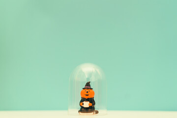 Fototapeta premium jack o lantern holding coffee cup stay home on green background.Stay home stay safe lockdown at home.Relax in holidays halloween party online.Protection from coronavirus covid19 pandemic.Pumpkin witch