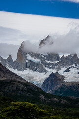 Rocky snowy mountain peaks with the sun rising behind and red clouds. Fitz Roy in Argentina