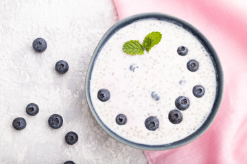 Yogurt with blueberry in ceramic bowl on gray concrete background. top view, flat lay.