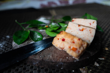 Fototapeta na wymiar Sliced Spiced cheese on a wooden plank closeup. 