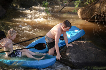 Two boys kayaking in rapids on Goulburn River in New South Wales near Mudgee. Holiday photos on Australian road trip.