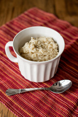 white mug of risotto on red place mat