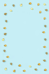 New Year glass balls golden colored, small shiny toys on blue paper.