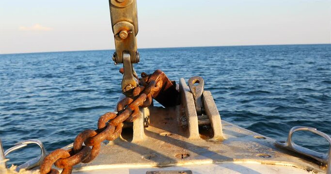 the bow of a yacht with an iron chain on the background of the open sea.