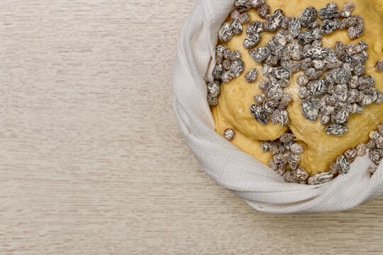 The step of adding the flour boned raisins on top of the fermented mixture, the puffed yeast dough risen in a bowl