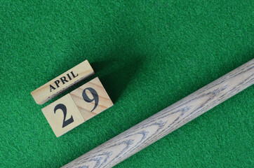 April 29, Number cube With a snooker stick on a green background, snooker table.