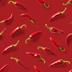Seamless pattern made of red chili or chilli on red background. Minimal food pattern. Red hot chilli seamless peppers pattern. Food background.