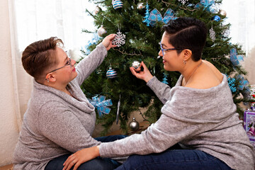 Obraz premium A young couple decorating the Christmas tree