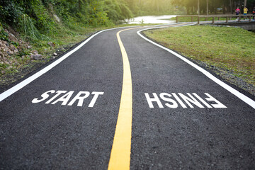 Beautiful park with jogging track with white text START and FINISH.