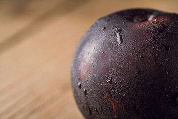 Freshly harvested red plum with condensation at cold autumn morning. Selective focus. Shallow depth of field.
