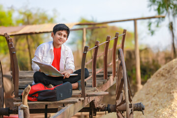 little boy seating on bull cart and studying