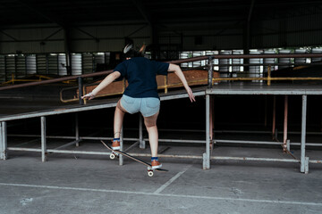 Fototapeta na wymiar Skate board player woman on stand on a board.