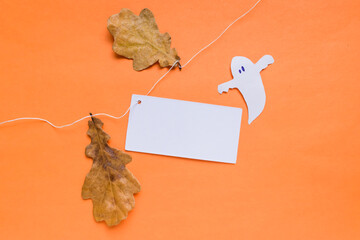 Happy Halloween holiday concept. Halloween decorations, spooky with yellow autumn leaves on an orange background. Card with frame for text.