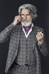 Portrait of bearded redhead English male. Senior smoking pipe in a studio.