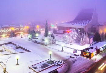 Omsk State Musical Theater and the theater square in front of it in heavy fog in the evening. Heavy fog over the city in winter in Omsk.