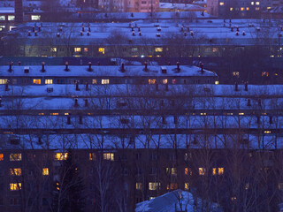 Five-story residential buildings in Omsk, many five-story buildings in the snow. Darkness in the city, residential buildings in the evening or at night from a height. Typical urban development