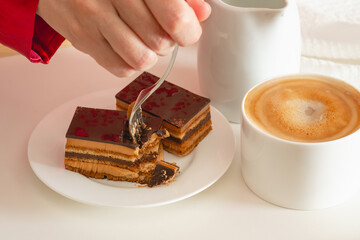 Cup of coffee with milk, and chocolate cake. Sweet delicious breakfast on a bed tray table