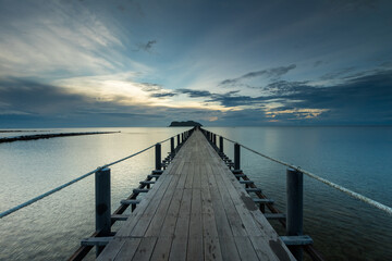 Obraz premium Wooden bridge stretching down to the sea to be used for boarding the boat at Thung Makham Noi Pier, Chumphon, Thailand