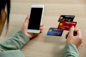 Businesswoman hand holding and use credit card to online shopping from home with smartphone, payment e-commerce, internet banking, spending money for next holidays