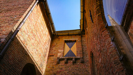 Fototapeta na wymiar A Look At The Walls, Entrance And Roof Of An Ancient Brick Christian Church In Bruges, Belgium