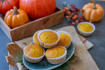 sweet home made vanilla pumpkin muffins on a table with pumpkins