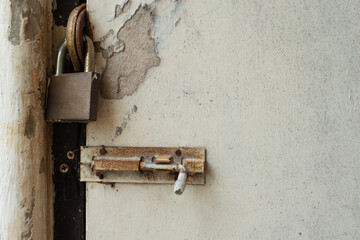 Rusty golden lock with locked wooden door background.