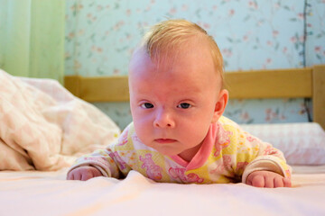 cute child baby infant trying to crawl on the bed