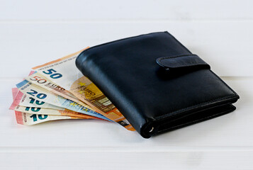 Black wallet on white wooden table