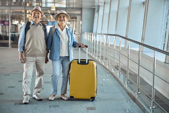 Joyous tourist couple standing at the airport