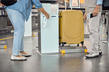 Passenger using a self-service kiosk for receiving a bag tag
