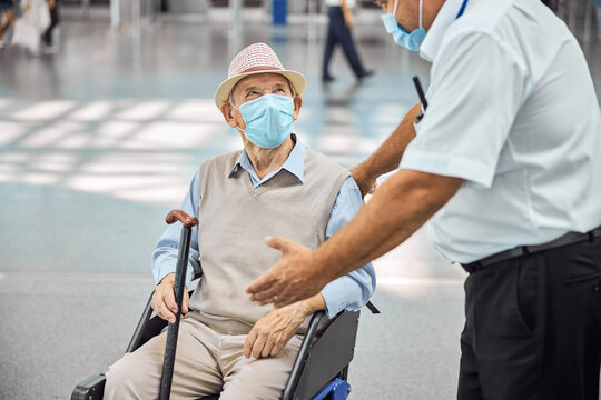 Airport Worker Talking To A Passenger In A Wheelchair