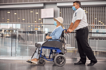 Disabled senior woman being conveyed to a plane
