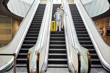 Two airline passengers going down the escalator