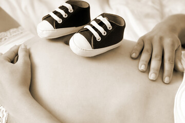 Babybauch mit Schuhen