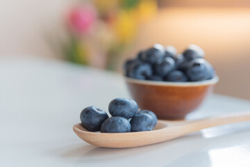 Blueberries in wooden spoon on the table.