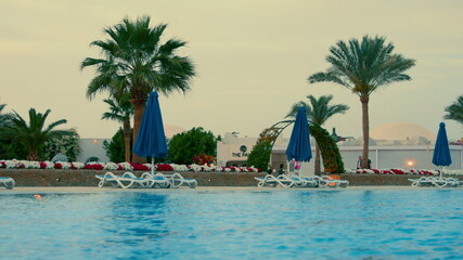 Fototapeta premium Beautiful swimming pool at hurghada resort in summer evening. Open air lido.