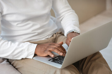 African-American man working on laptop at home, closeup