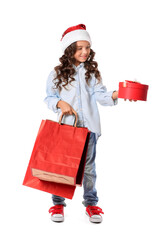 Cute little girl in Santa hat, with shopping bags and gift on white background
