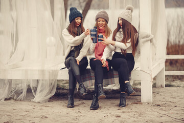 Fototapeta premium Friends in a winter park. Girls in a knited hats. Women with thermos and tea.