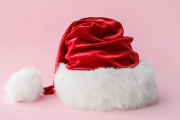 Santa Claus hat on color background