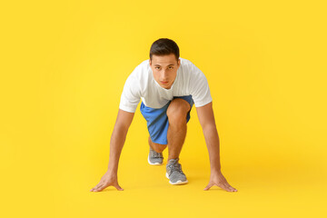 Fototapeta na wymiar Sporty young man on color background. Concept of goal achievement