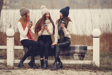 Friends in a winter park. Girls in a knited hats. Women with thermos and tea.