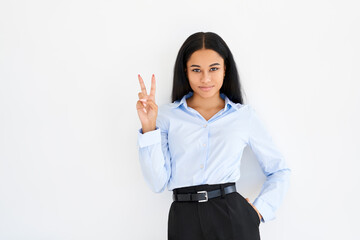Obraz premium Happy smiling black businesswoman doing victory sign on white background