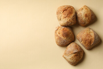 Fresh baked buns on beige background, top view