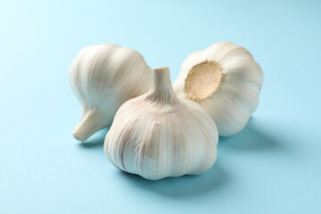 Obraz na płótnie Canvas Raw garlic on blue background, close up