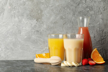 Jars with different juices against gray background