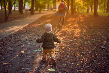 one and a half year old child running in the park in autumn