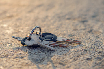 A lost keys on the ring on the ground illuminated with sun rays, selective focus