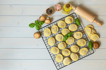Fresh raw italian filled pasta ravioli or tortelli with mushrooms, pesto, and ricotta.